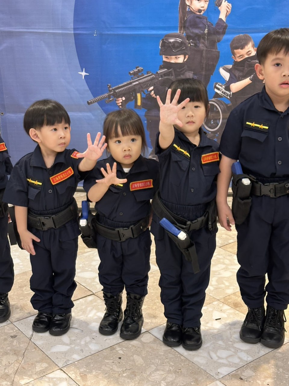穿著警察制服的孩子們排成一列打招呼